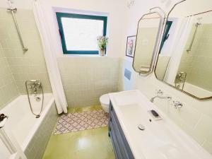 a bathroom with a sink and a tub and a toilet at NEW - Casa Palamós - Charming historical home with patio, in the heart of the old town, 100m from beach in Palamós +20 photos