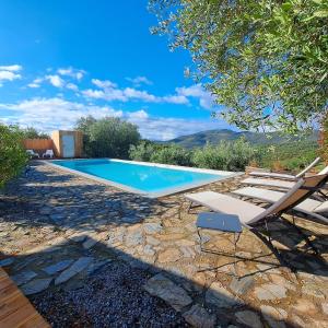 a swimming pool with two lounge chairs next to it at Mas del Sola in Castelnou