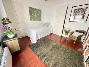 a small room with a bed and a rug at NEW - Casa Palamós - Charming historical home with patio, in the heart of the old town, 100m from beach in Palamós