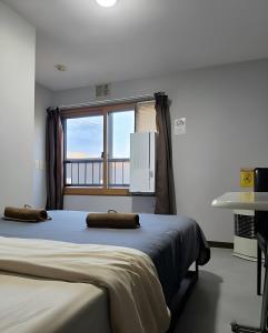 a bedroom with a large bed and a window at Snow Nest Lodge in Sapporo
