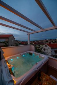 a jacuzzi tub on a balcony with a view at Captain's Escape - Spa City View in Mali Lošinj