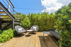 a garden with two chairs and a table on a deck at The Weekender Hotel in San Juan