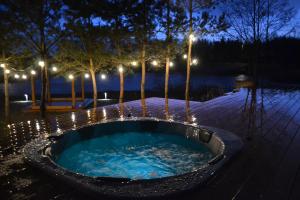 a hot tub with lights in a park at night at Słoneczna Polana in Żabiczyn