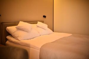a bed with white sheets and pillows on it at Słoneczna Polana in Żabiczyn