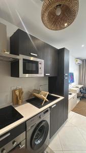 a kitchen with a washing machine and a microwave at Luxury Studio Condo in Accra