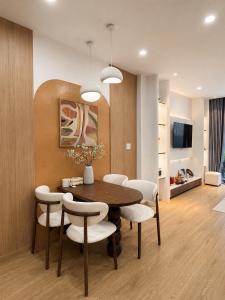 a dining room with a table and white chairs at Linh's Home in Danang