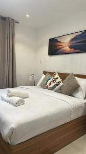 a bed with white sheets and pillows on it at Luxury Studio Condo in Accra