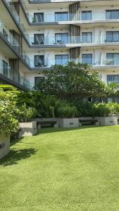 a large apartment building with benches in a grass field at Luxury Studio Condo in Accra
