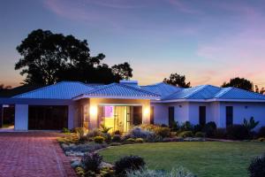 a house with a blue roof at dusk at Sarum Lodge in Harare