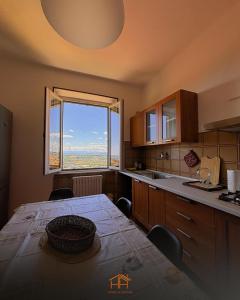 a kitchen with a table and a large window at La Cameranense by Homes in Ancona in Camerano