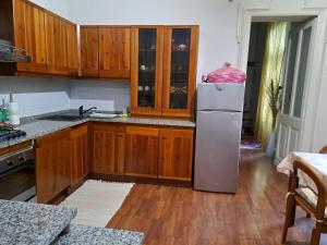 a kitchen with wooden cabinets and a refrigerator at Appartamento Le Corti 2 in Alessandria +37 photos