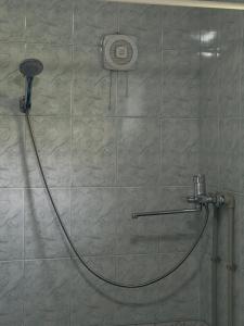 a shower with a hose attached to a tiled wall at Village stay in Kaindy +41 photos