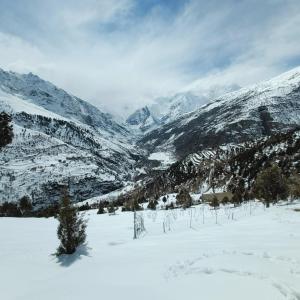 a snow covered valley with mountains in the distance at Gremuspa Homestay in Kyelang