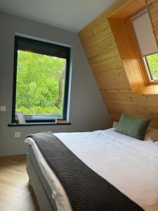 a bedroom with a bed and a large window at AHA Cabin in Comarnic