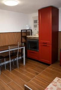 a kitchen with a stove and a table and a red cabinet at I Masselli Home - Appartamento in villa in Trezzano sul Naviglio