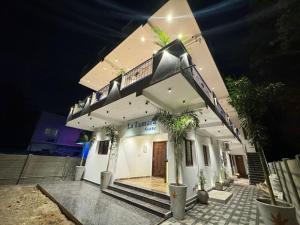 a large white building with plants on it at night at Le Tamara Suite - TIE in Auroville