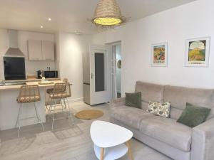 a living room with a couch and a kitchen at Le Cosy Caladois in Villefranche-sur-Saône