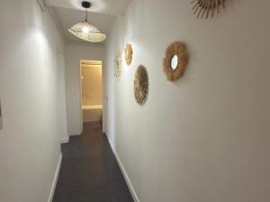 a hallway with two mirrors on a white wall at Le Cosy Caladois in Villefranche-sur-Saône