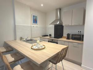 a kitchen with a table with chairs and a sink at Le Cosy Caladois in Villefranche-sur-Saône