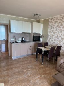 a kitchen and dining room with a table and chairs at Infinity Sea View Deluxe Apartment in Pomorie