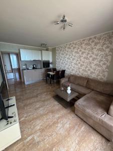 a living room with a couch and a table at Infinity Sea View Deluxe Apartment in Pomorie