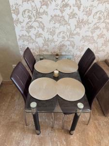 a dining room table with two chairs and a glass table and chairs at Infinity Sea View Deluxe Apartment in Pomorie