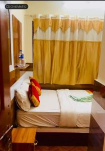 a bedroom with a bed with a yellow curtain at pokhara hotel Kathmandu pvt ltd in Kathmandu