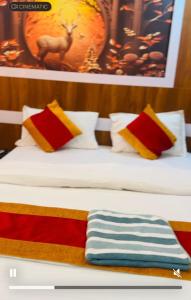 a bed with colorful pillows and a towel on it at pokhara hotel Kathmandu pvt ltd in Kathmandu