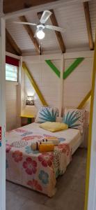a bedroom with a bed in a room with a ceiling at Méline in Baie-Mahault