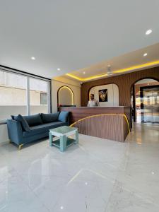 a lobby with a blue couch and a table at Hotel Sai Mahima, Near Sai Baba Temple in Shirdi