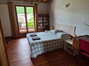 a bedroom with a bed and a desk and a window at Le Rucan Maison atypique in Montastruc-de-Salies