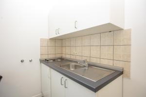 a kitchen with a sink and white cabinets at Apartmani Liovic in Duće +139 photos
