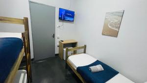 a room with two bunk beds and a tv at Central Suites - Hospedagem Super Econômica in Rio Verde