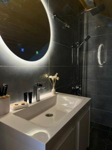 a bathroom with a white sink and a mirror at Cabin AISI in (( Gergeti )) +13 photos