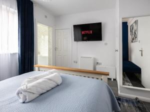a bedroom with a bed with a mirror and a tv at Reverie Escape by Halisi in Ramsgate