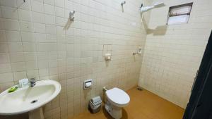 a bathroom with a toilet and a sink at Central Suites - Hospedagem Super Econômica in Rio Verde