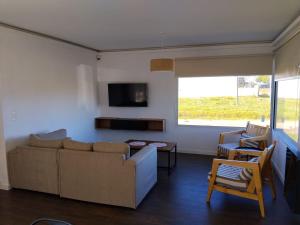 a living room with a couch and a tv at Villa Pi in Miramar