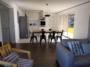 a living room with a table and chairs and a kitchen at Villa Pi in Miramar