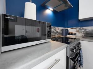 a kitchen with a microwave on top of a counter at Reverie Escape by Halisi in Ramsgate