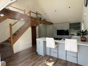 a kitchen with white cabinets and a staircase at Ash Tree Lodge in Norwich