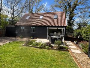 a small house with a table and chairs in the yard at Ash Tree Lodge in Norwich