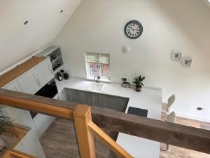 a kitchen with a sink and a clock on the wall at Ash Tree Lodge in Norwich