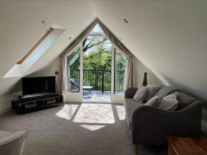 a living room with a couch and a large window at Ash Tree Lodge in Norwich