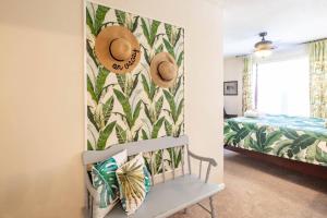 a bedroom with a bench and hats on a wall at Herons' Haven in Charleston