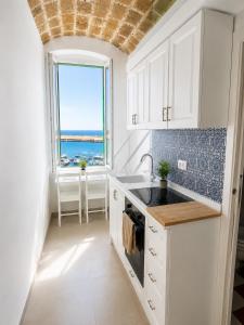 a kitchen with a view of the ocean from a window at B&B TORRE AZUL FRONTEMARE - Giovinazzo in Giovinazzo +15 photos