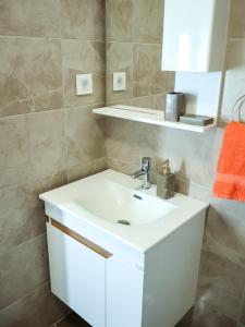a bathroom with a white sink and a mirror at Nada Apartman in Prijedor +19 photos