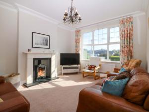 a living room with a couch and a fireplace at Bryniau in Pwllheli