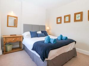 a bedroom with a large bed with blue pillows at Bryniau in Pwllheli
