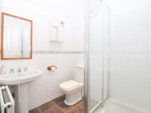 a white bathroom with a toilet and a sink at Bryniau in Pwllheli +35 photos
