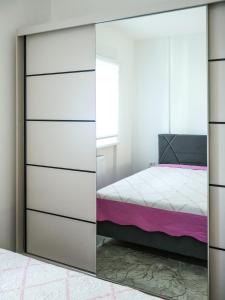 a mirrored wardrobe in a bedroom with a bed at Nada Apartman in Prijedor